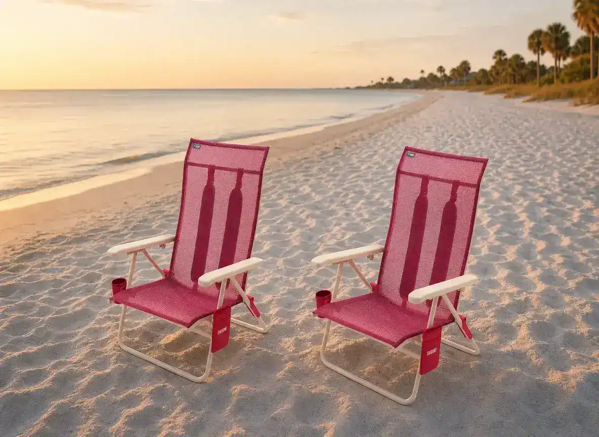 Two Shibumi Classic Pink beach chairs at golden hour on a Lowcountry beach with palmetto trees